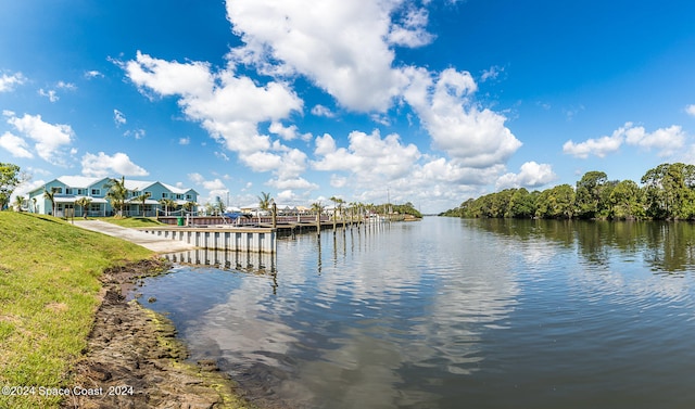 dock area with a lawn and a water view