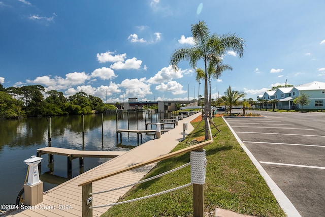 dock area featuring a lawn and a water view