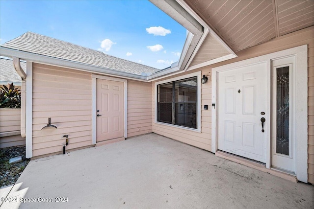 view of exterior entry featuring a patio area