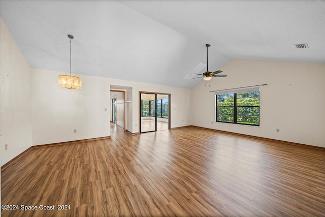 unfurnished living room with lofted ceiling, ceiling fan with notable chandelier, and hardwood / wood-style flooring