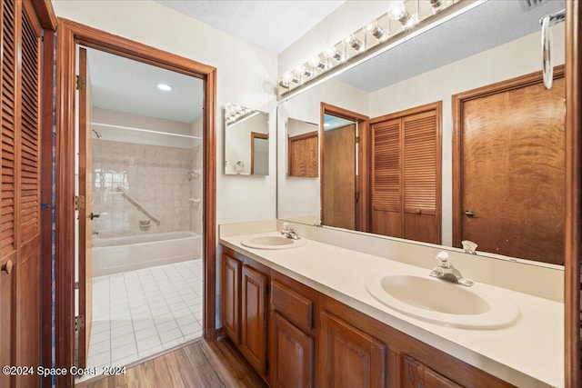 bathroom featuring vanity, wood-type flooring, and tiled shower / bath combo