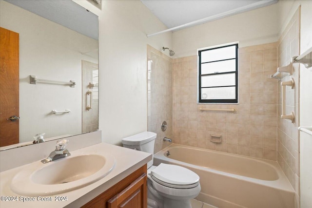 full bathroom featuring tiled shower / bath, vanity, and toilet