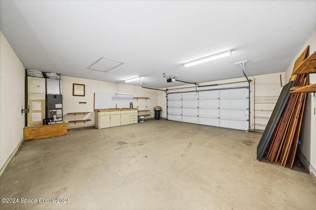 garage featuring heating unit and a garage door opener