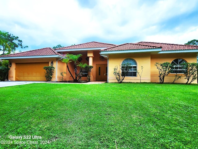 mediterranean / spanish house with a front lawn and a garage