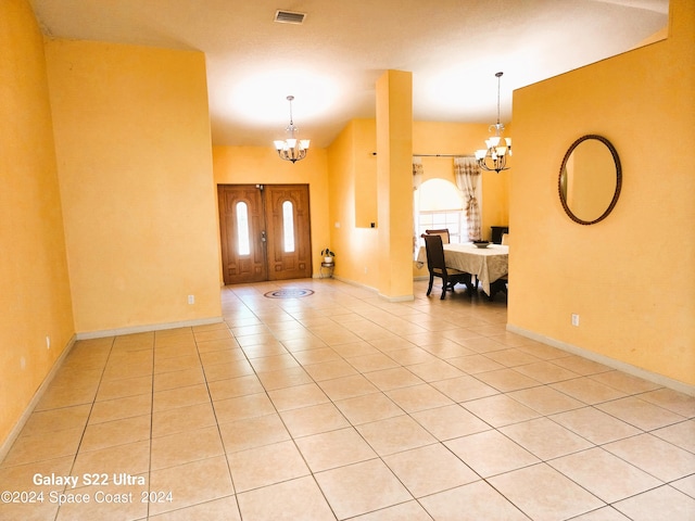 tiled foyer featuring an inviting chandelier