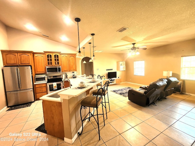 kitchen featuring hanging light fixtures, sink, stainless steel appliances, and plenty of natural light