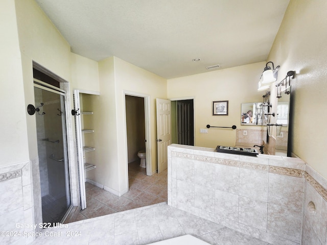 bathroom featuring tile patterned floors, a shower with shower door, and toilet