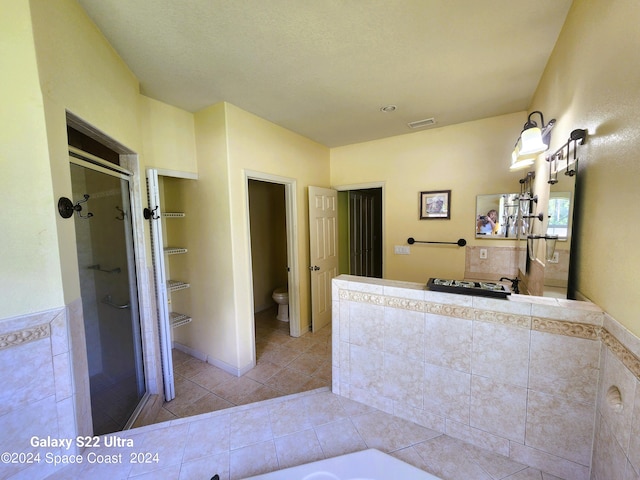 bathroom with shower with separate bathtub, toilet, and tile patterned floors