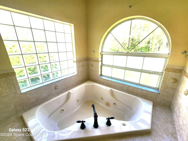 bathroom featuring tiled bath and a healthy amount of sunlight