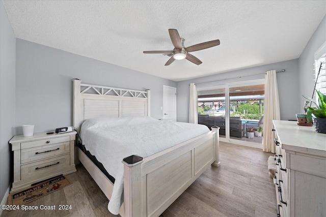 bedroom with access to exterior, a textured ceiling, light wood-type flooring, and ceiling fan