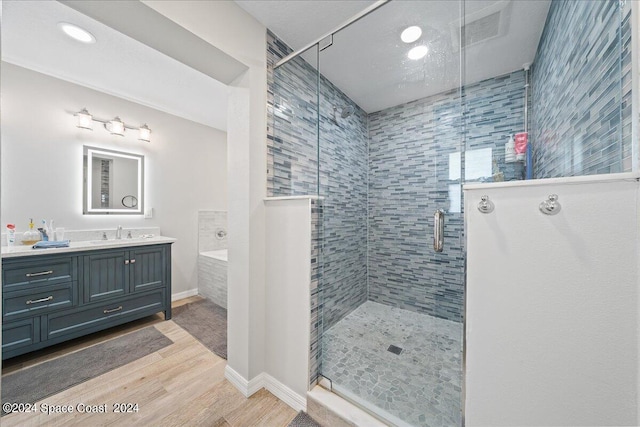 bathroom featuring hardwood / wood-style floors, vanity, and a shower with shower door