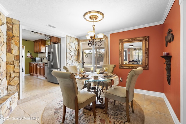 tiled dining area with a textured ceiling, crown molding, and an inviting chandelier