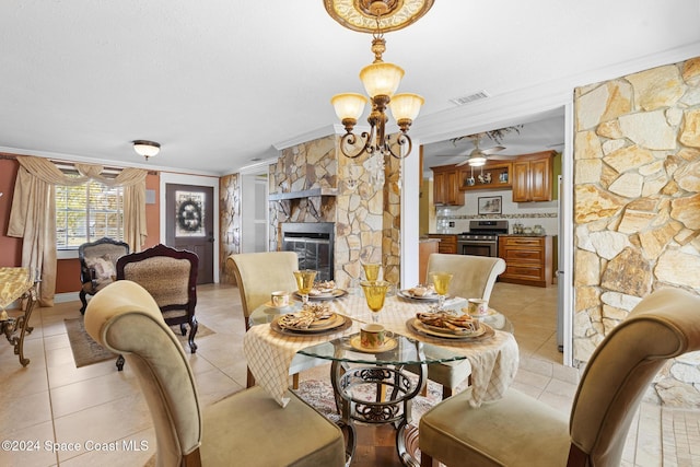 dining area featuring an inviting chandelier, crown molding, light tile patterned floors, and a fireplace