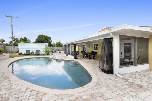 view of swimming pool featuring a patio area and a sunroom