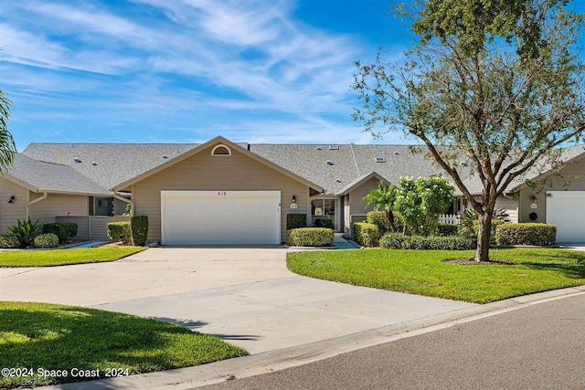 single story home with a garage and a front lawn