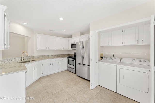 washroom with sink, light tile patterned floors, a textured ceiling, and independent washer and dryer