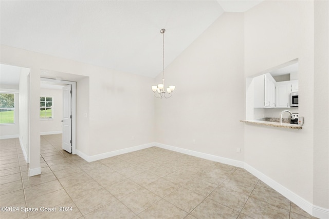 unfurnished dining area with sink, light tile patterned floors, a notable chandelier, and high vaulted ceiling