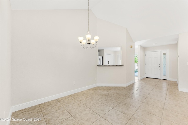 empty room featuring high vaulted ceiling, light tile patterned floors, and a notable chandelier