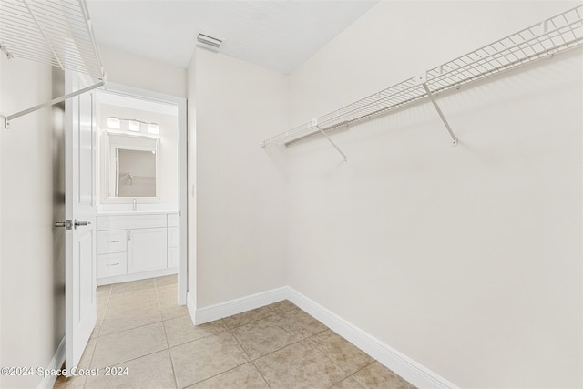 walk in closet with light tile patterned flooring