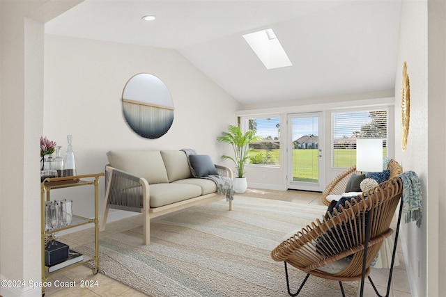 sitting room with vaulted ceiling with skylight and light tile patterned floors