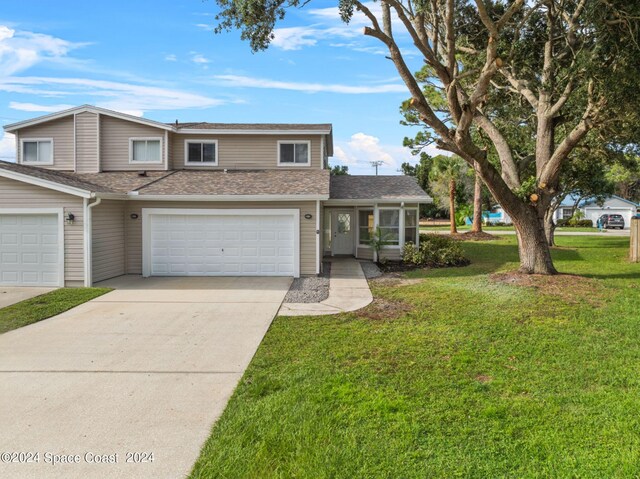 front of property with a garage and a front lawn