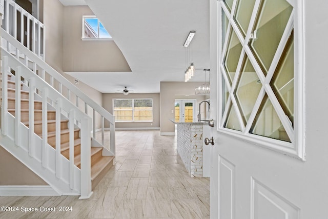 entrance foyer with ceiling fan with notable chandelier