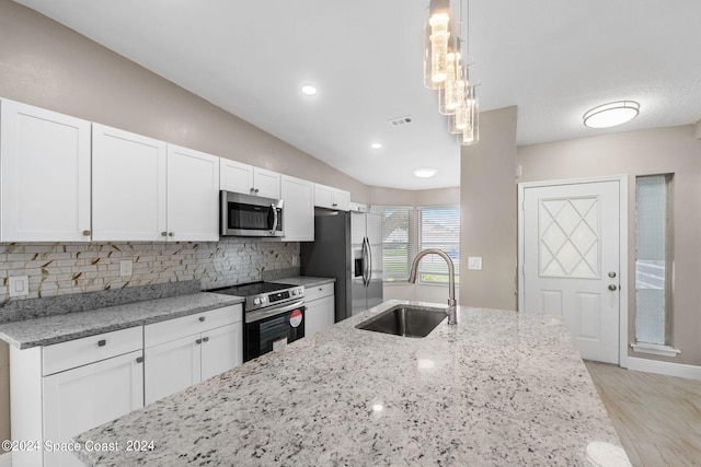 kitchen with white cabinetry, appliances with stainless steel finishes, hanging light fixtures, and sink