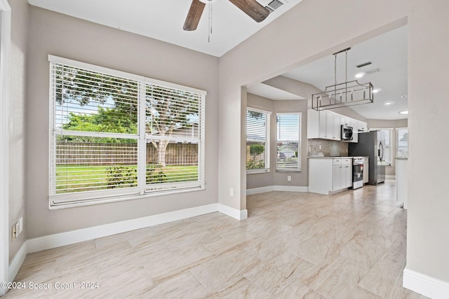 unfurnished living room with ceiling fan and a healthy amount of sunlight