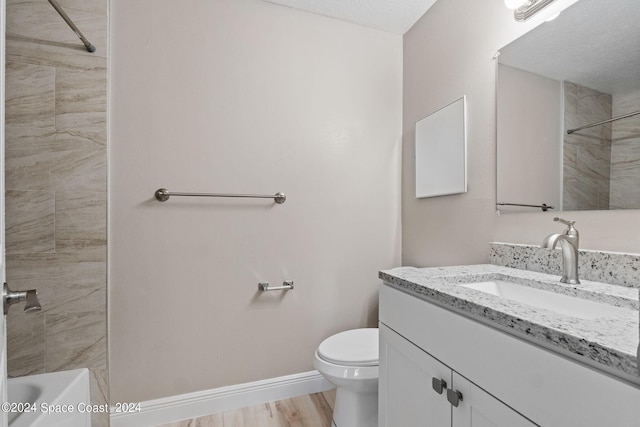 full bathroom featuring vanity, tiled shower / bath combo, a textured ceiling, hardwood / wood-style flooring, and toilet