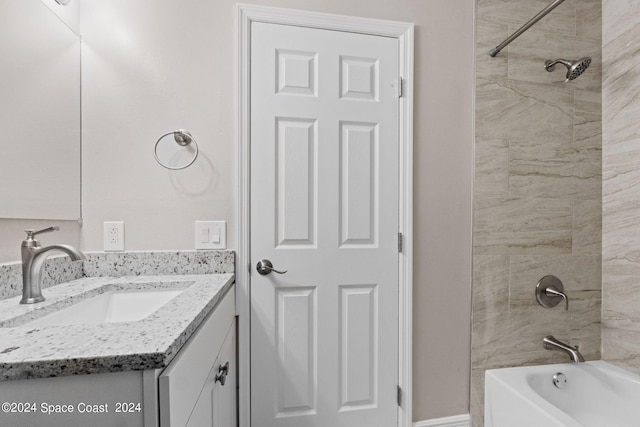 bathroom featuring tiled shower / bath and vanity