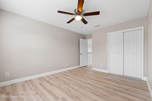 unfurnished bedroom with ceiling fan, light hardwood / wood-style flooring, and a closet