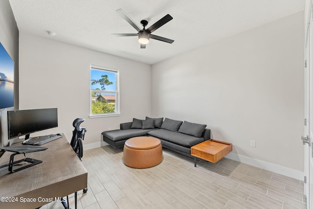 home office with ceiling fan, a textured ceiling, and light hardwood / wood-style flooring