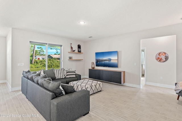 living room featuring a textured ceiling and light hardwood / wood-style flooring