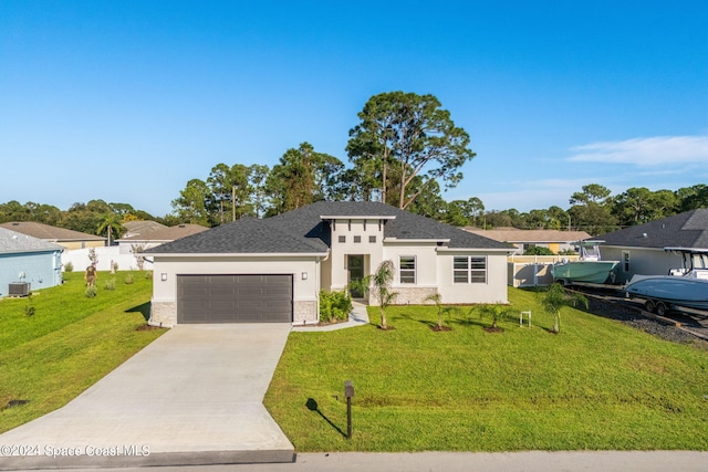 view of front of property with a front lawn, central AC unit, and a garage