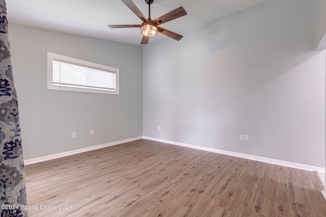 spare room with a textured ceiling, ceiling fan, and light hardwood / wood-style flooring