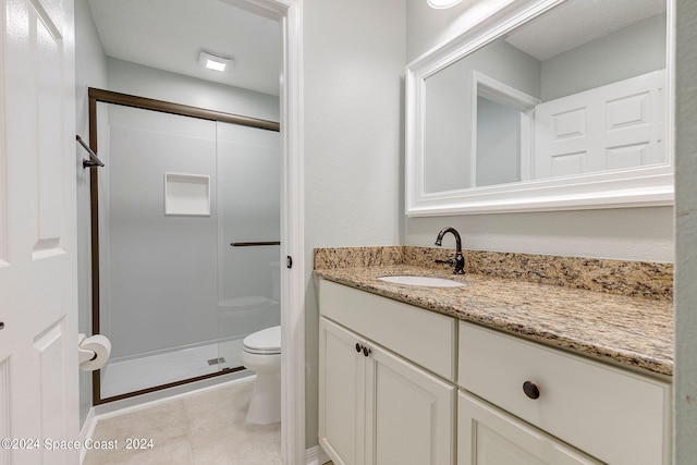 bathroom featuring a shower with door, tile patterned floors, vanity, and toilet