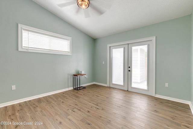 unfurnished room featuring ceiling fan, french doors, vaulted ceiling, and plenty of natural light