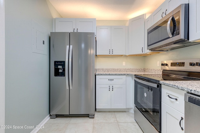 kitchen featuring light stone counters, electric panel, stainless steel appliances, white cabinetry, and light tile patterned flooring