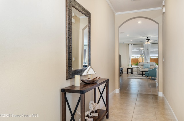 hallway featuring light tile patterned floors and ornamental molding