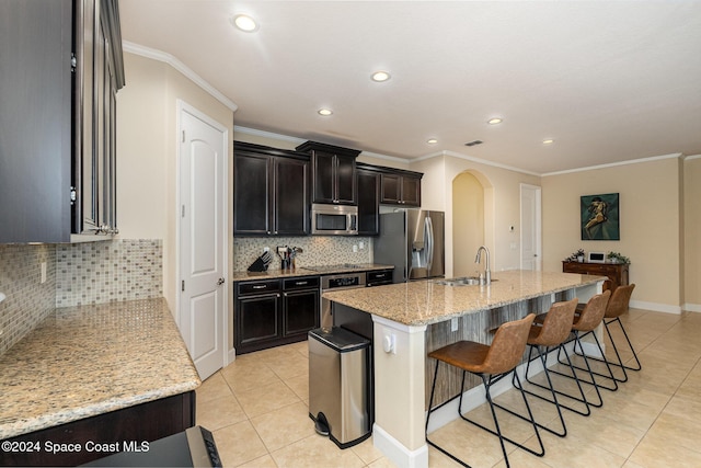 694 Mission Bay Dr, Satellite Beach, FL 32937 - kitchen featuring appliances with stainless steel finishes, a sink, crown molding, arched walkways, and light tile patterned floors