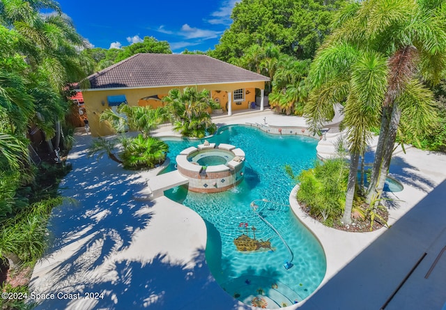 view of swimming pool featuring a patio and an in ground hot tub