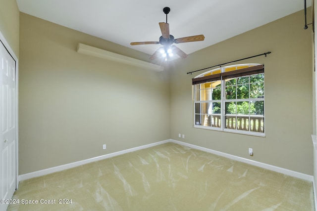 spare room featuring ceiling fan and light carpet