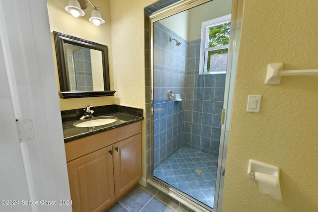 bathroom featuring vanity, tile patterned flooring, and an enclosed shower