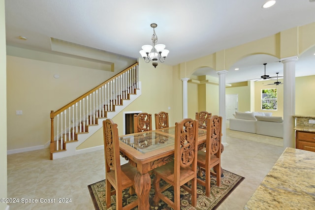 tiled dining area with ceiling fan with notable chandelier and decorative columns