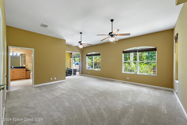 carpeted spare room with ceiling fan