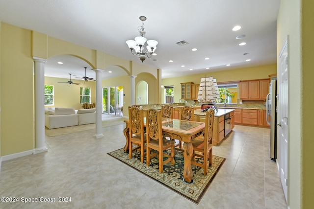 tiled dining area featuring ceiling fan with notable chandelier and ornate columns