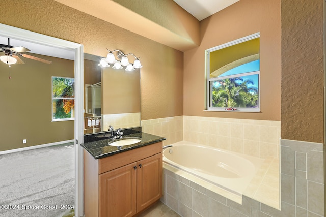 bathroom with a healthy amount of sunlight, vanity, ceiling fan, and plus walk in shower