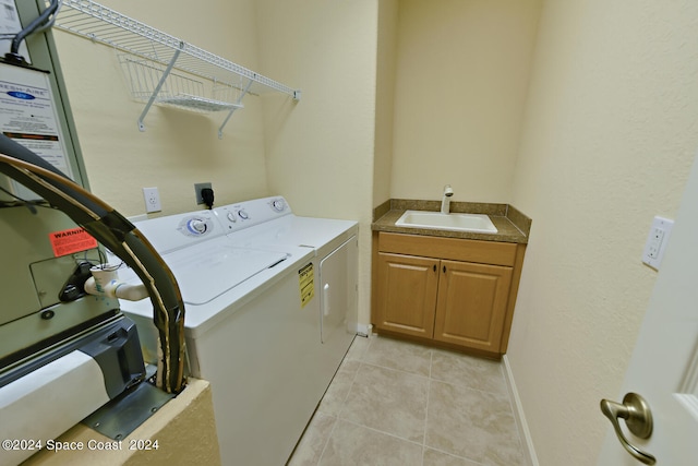 clothes washing area with light tile patterned floors, sink, and washer and dryer