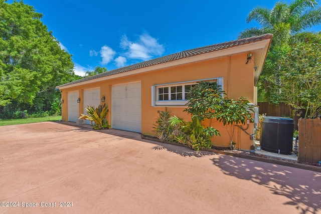 view of front of property with a patio, central AC, and a garage