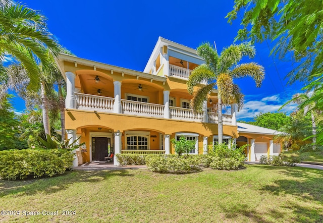 view of front of property featuring a front yard, a balcony, and ceiling fan